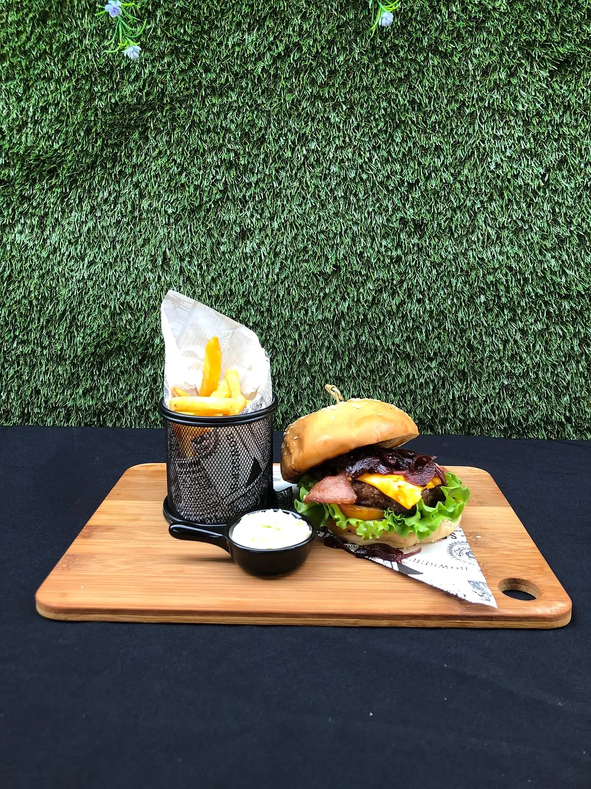 Burger with fries on a wooden serving board